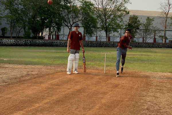Students playing cricket on the ground
